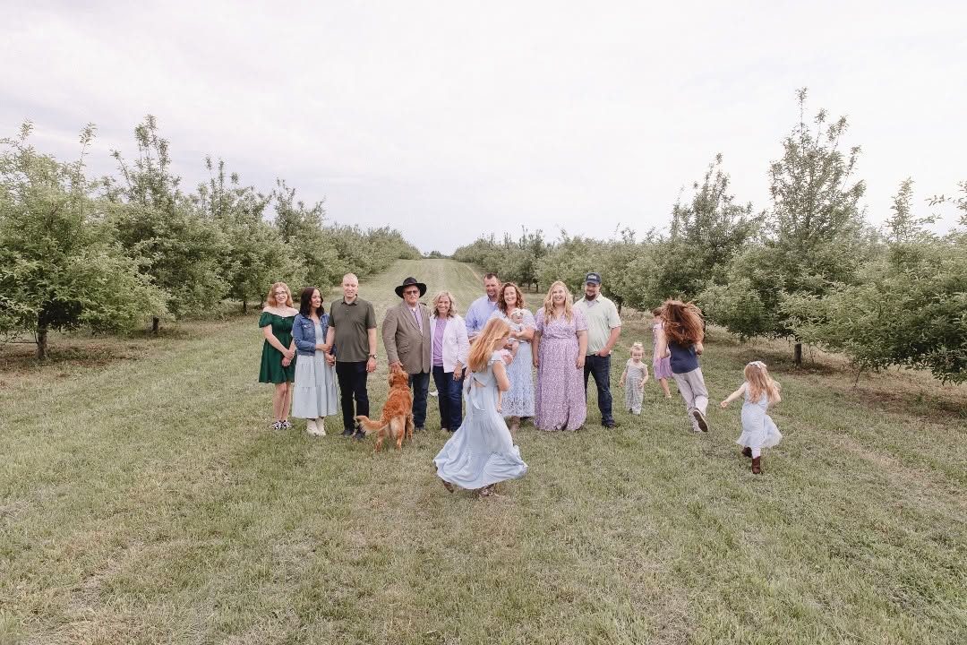 The White House Foods family standing among apple crates in the orchard
