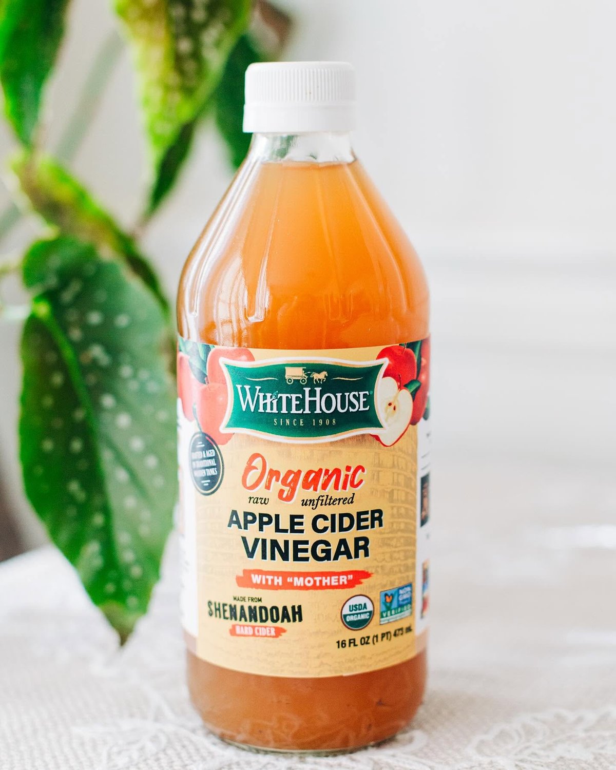 A bottle of White House organic raw unfiltered apple cider vinegar with the mother